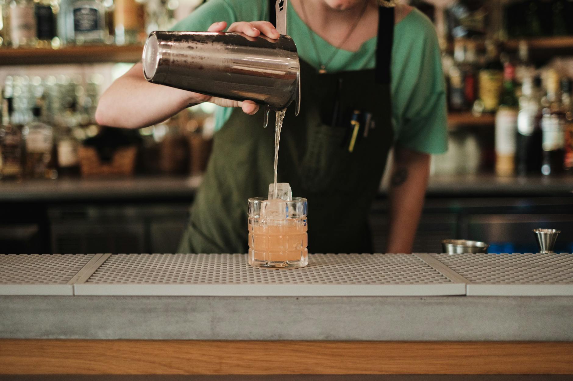 Cocktail bar with bartender mixing drinks at night