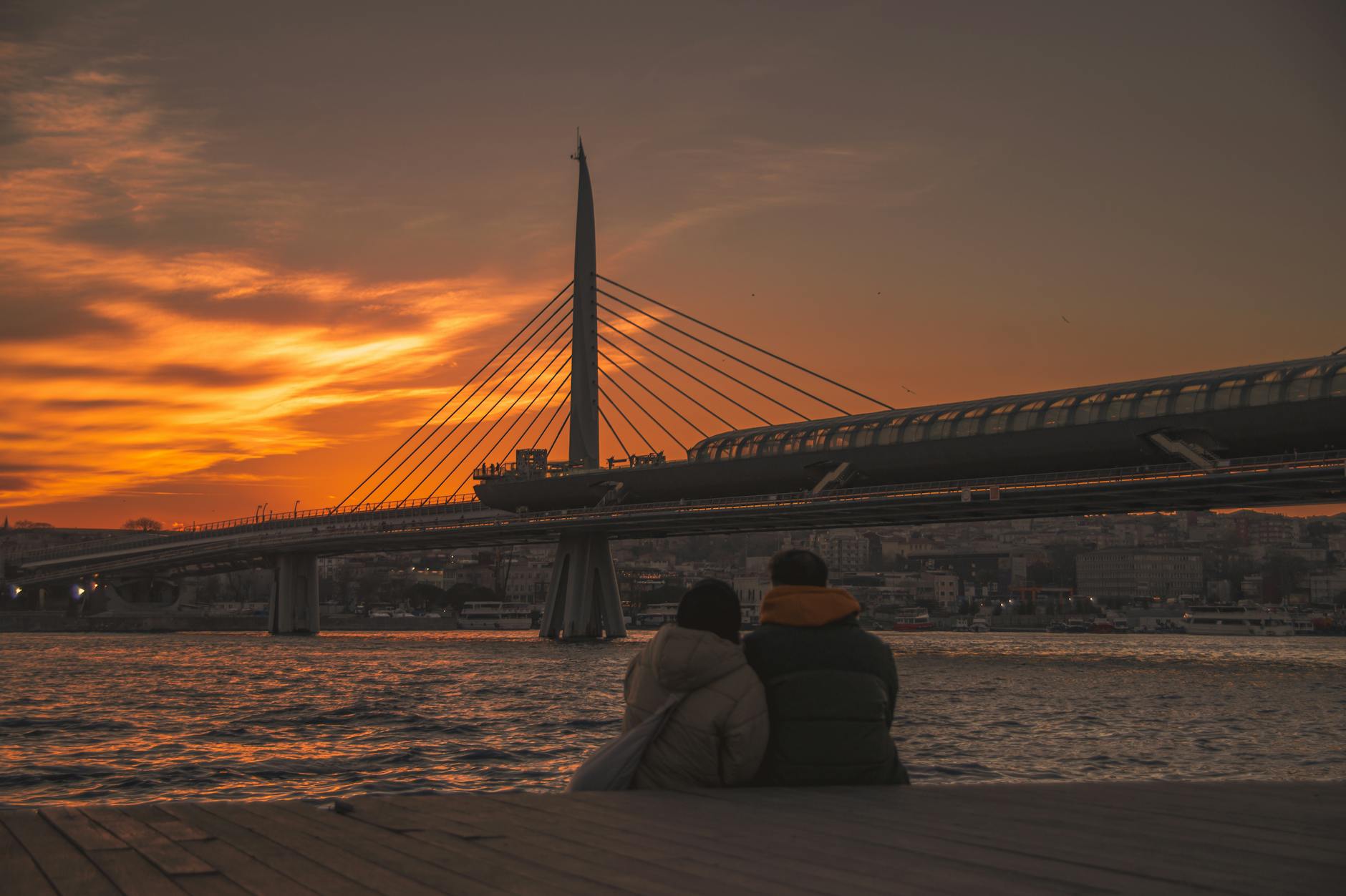 Romantic things to do in Stockholm — a couple watching sunset from a bridge over the water