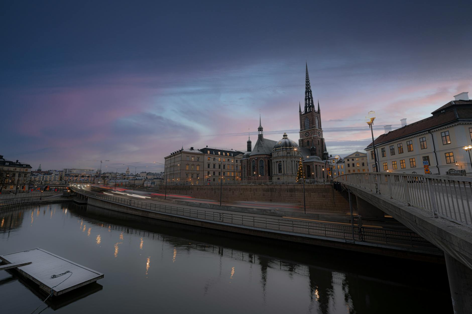 Twilight view of Riddarholmen Church and the Stockholm waterfront with a bridge in the foreground