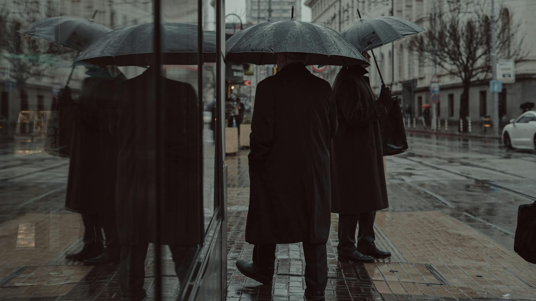 Stockholm when it rains — wet street with umbrella and reflections