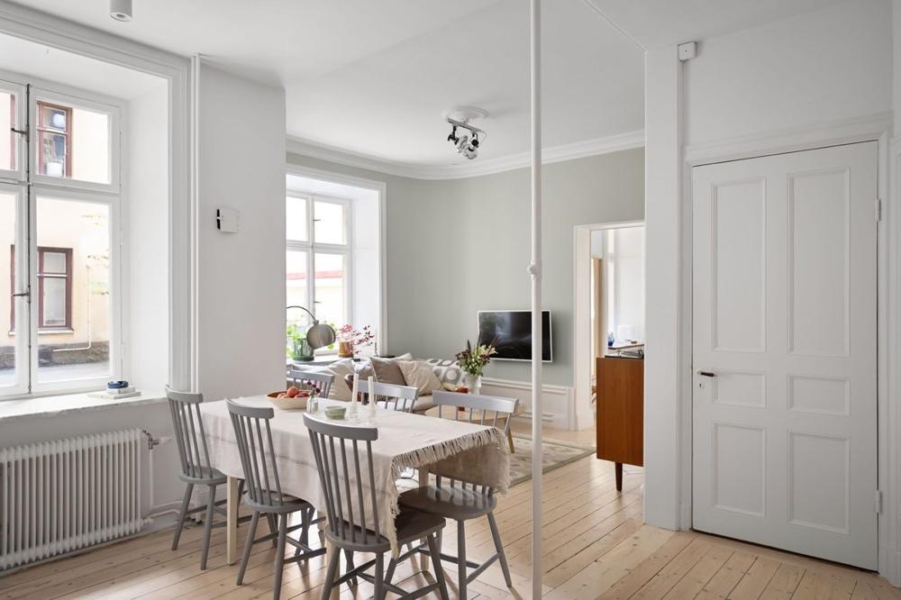 Bright Scandinavian living room in a Stockholm apartment rental with a kitchen and light wood floors