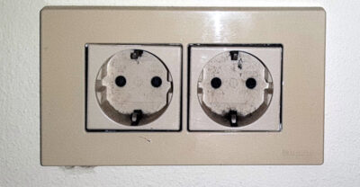 A double Type F Schuko wall socket with two round recessed outlets and side earth clips