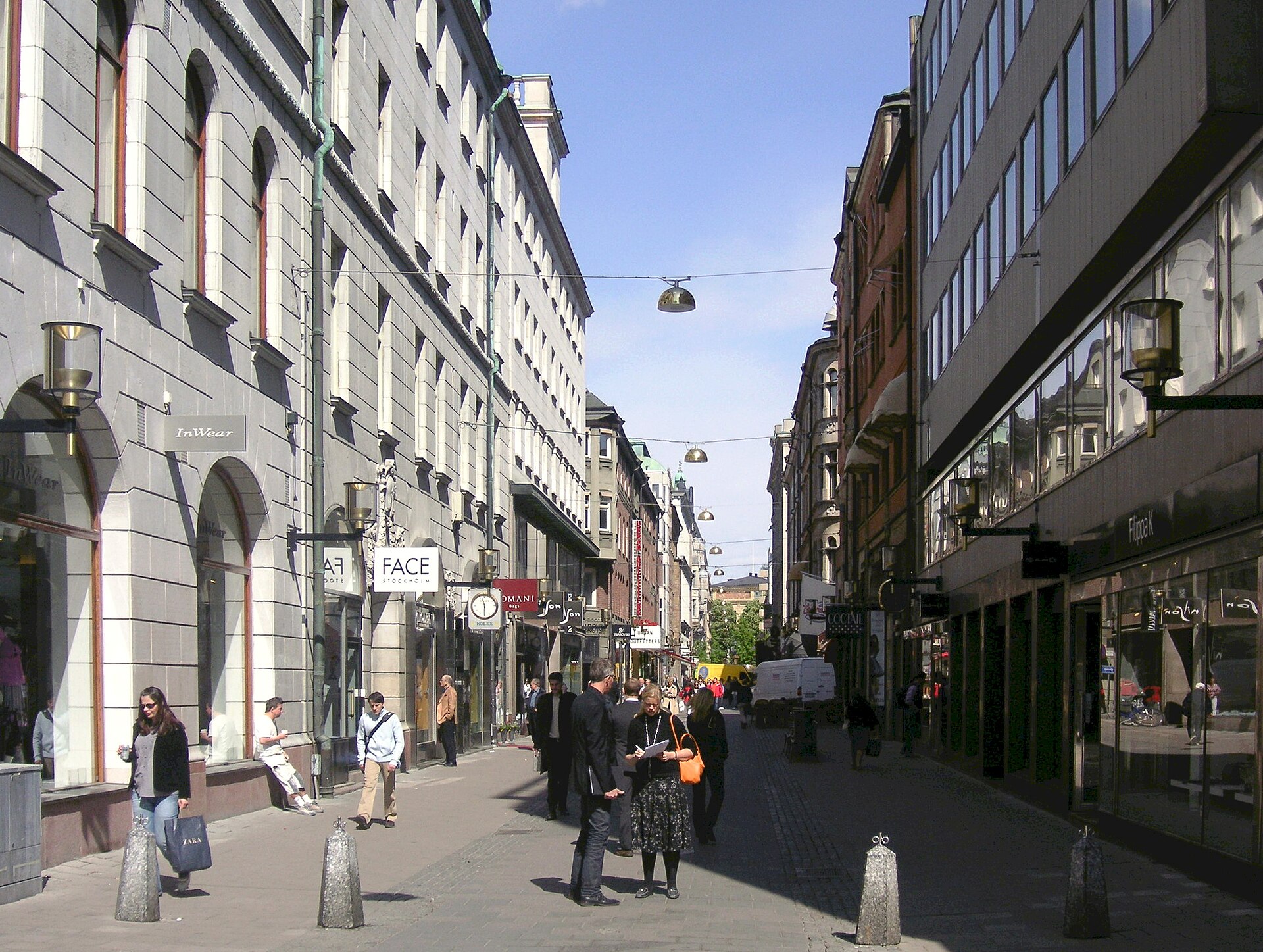 Shoppers on the pedestrianised Biblioteksgatan in Stockholm with boutique storefronts on both sides