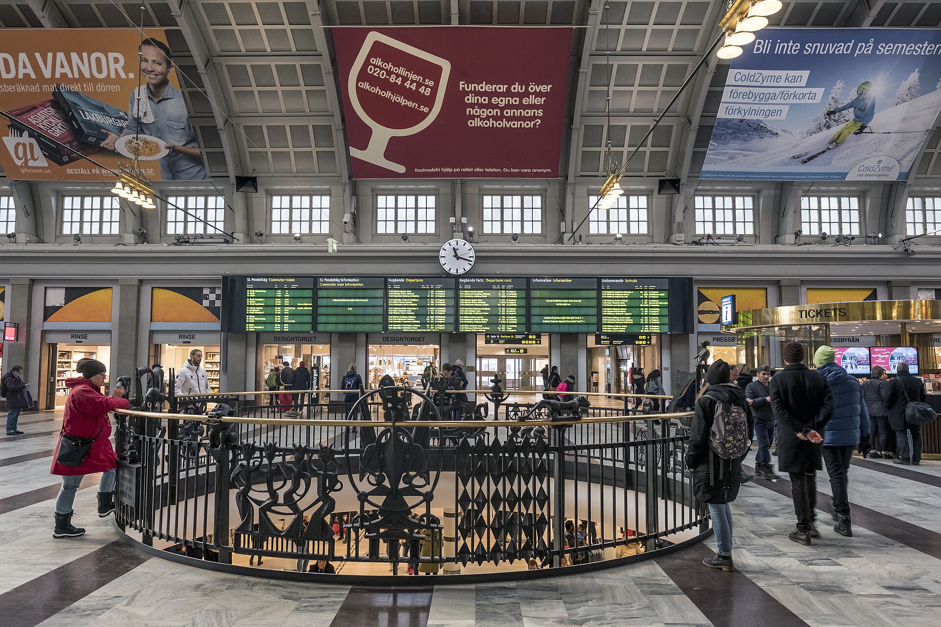 The main hall of Stockholm Central Station with its arched ceiling, departure boards and travellers walking across the stone floor