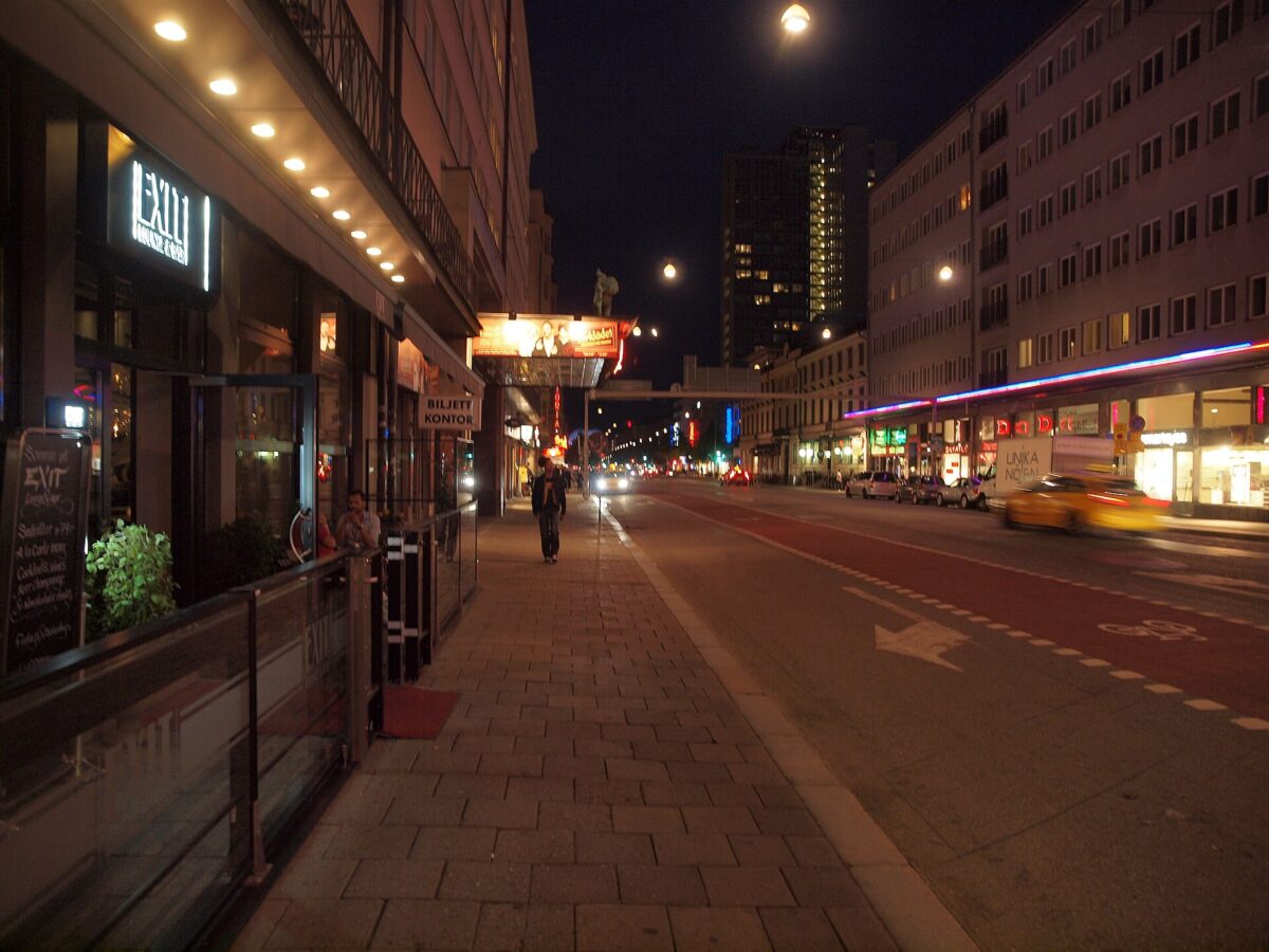 Götgatan in Stockholm at night, with lit bar and cinema signs along the street