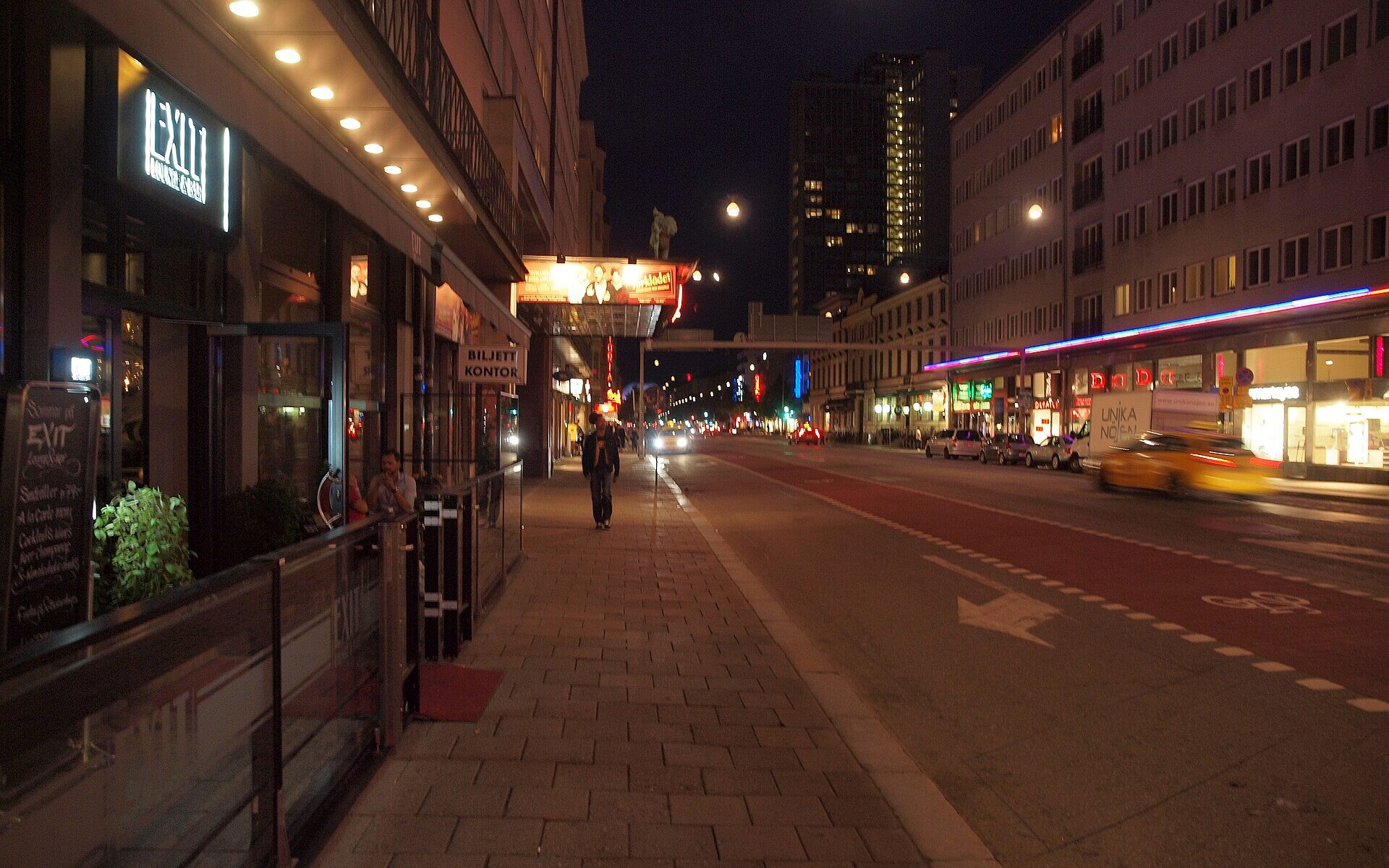 Götgatan in Stockholm at night, with lit bar and cinema signs along the street