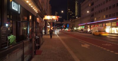 Götgatan in Stockholm at night, with lit bar and cinema signs along the street