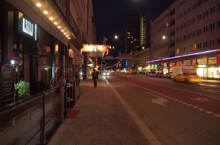 Götgatan in Stockholm at night, with lit bar and cinema signs along the street