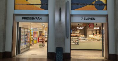 Side-by-side Pressbyrån and 7-Eleven convenience store entrances inside Stockholm Central Station