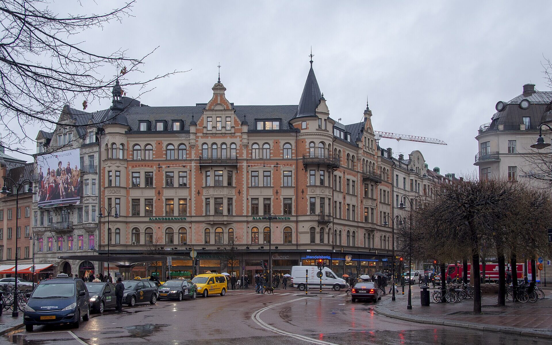 The Stureplan crossroads in Stockholm on a wet grey day, with taxis and turreted corner buildings