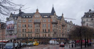 The Stureplan crossroads in Stockholm on a wet grey day, with taxis and turreted corner buildings