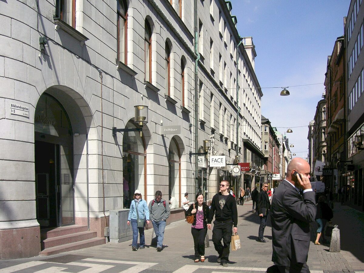 Shoppers walking along Biblioteksgatan, Stockholm's pedestrian luxury shopping street, on a sunny day