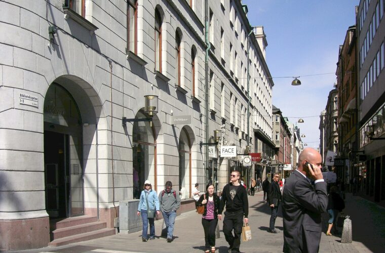 Shoppers walking along Biblioteksgatan, Stockholm's pedestrian luxury shopping street, on a sunny day